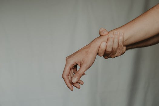 A close-up of two hands gently holding each other, symbolizing support and connection.